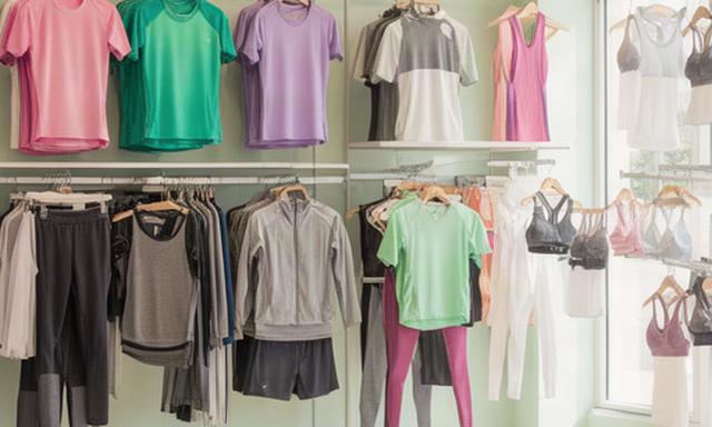 Sportkleding voor voetbal, hardlopen, tennis en yoga op rekken in een lichte winkel in Vlagtwedde