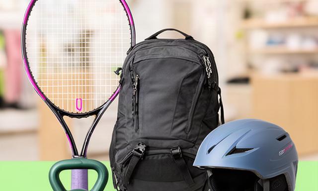 Sportuitrusting met tennisracket, kettlebell, rugzak en skihelm in een lichte winkelomgeving